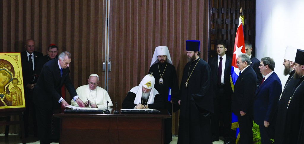 Pope Francis and Patriarch Kirill sign the Joint Declaration at the José Martí International Airport in Havana, February 12, 2016, with a Theotokos icon to the left, Raúl Castro and Metropolitan Hilarion watching, and the Cuban flag behind them