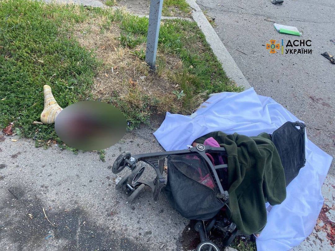 Overturned baby stroller next to a covered body on the street in Vinnytsia after the Russian missile strike, July 14, 2022