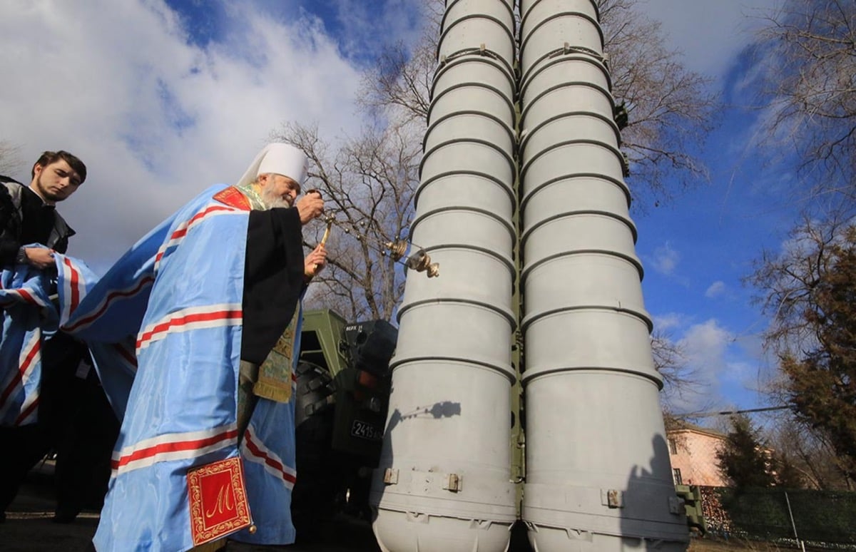 A metropolitan bishop blessing an S-400 Triumf surface-to-air missile system at a Russian military base