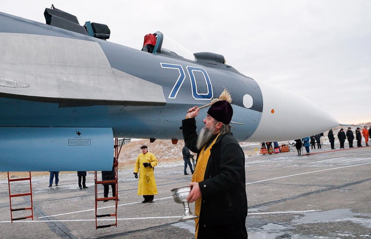 A priest sprinkling holy water on a Sukhoi Su-30SM fighter jet at Chernyakhovsk Air Base, Kaliningrad