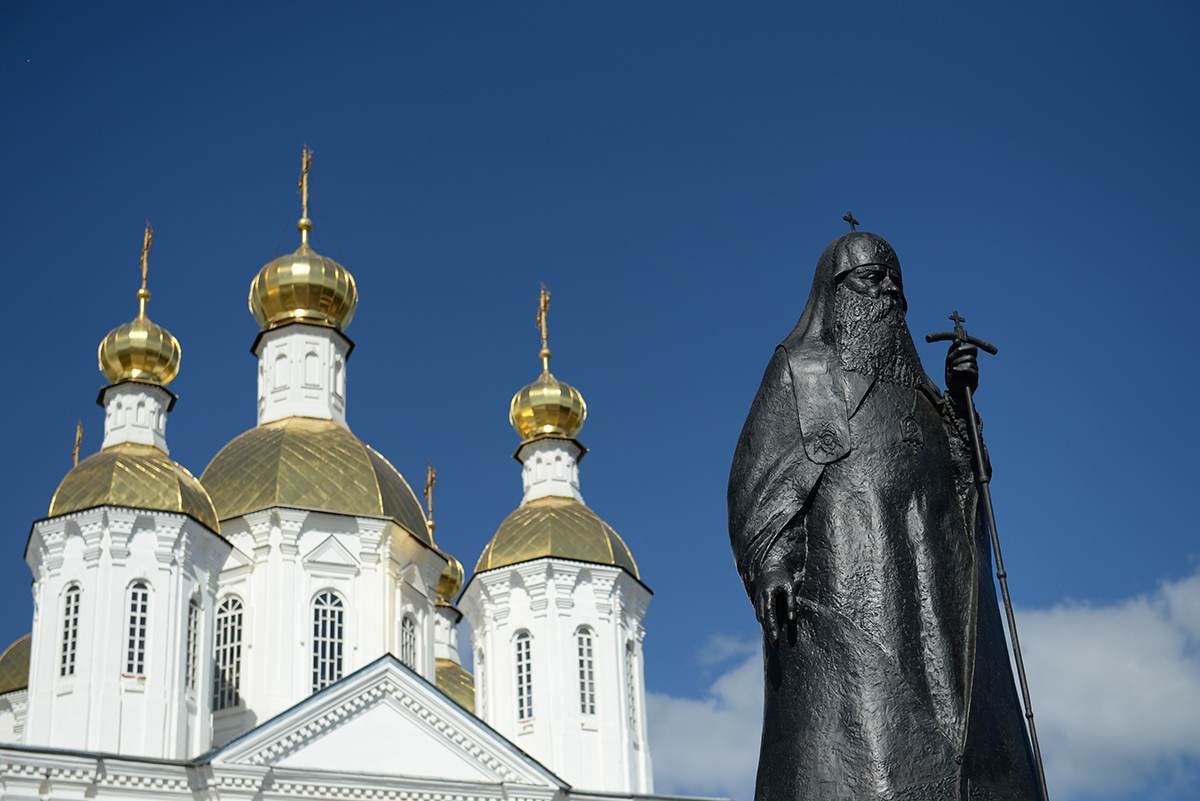 The Patriarch Sergius monument against the gold domes of the Resurrection Cathedral in Arzamas