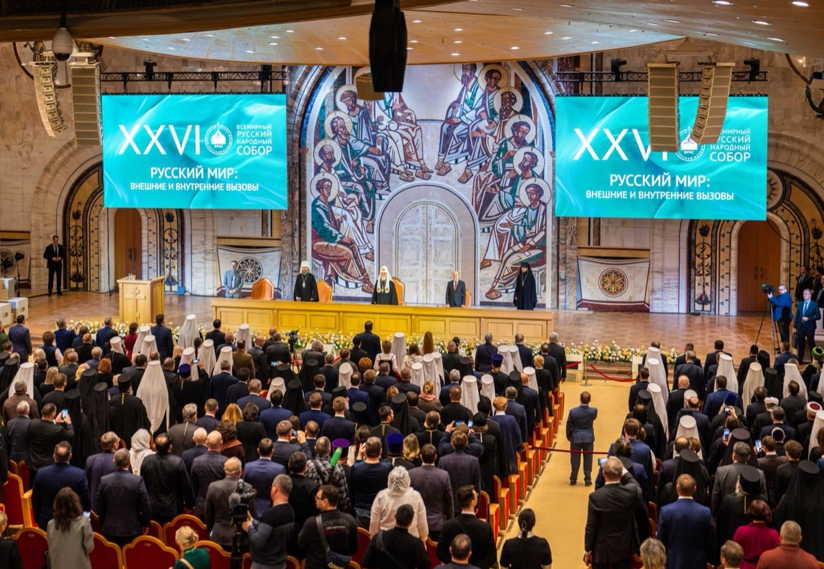 The XXVI World Russian People's Council in session at the Cathedral of Christ the Saviour, with banners reading "Russian World: External and Internal Challenges" flanking the stage and thousands of delegates standing