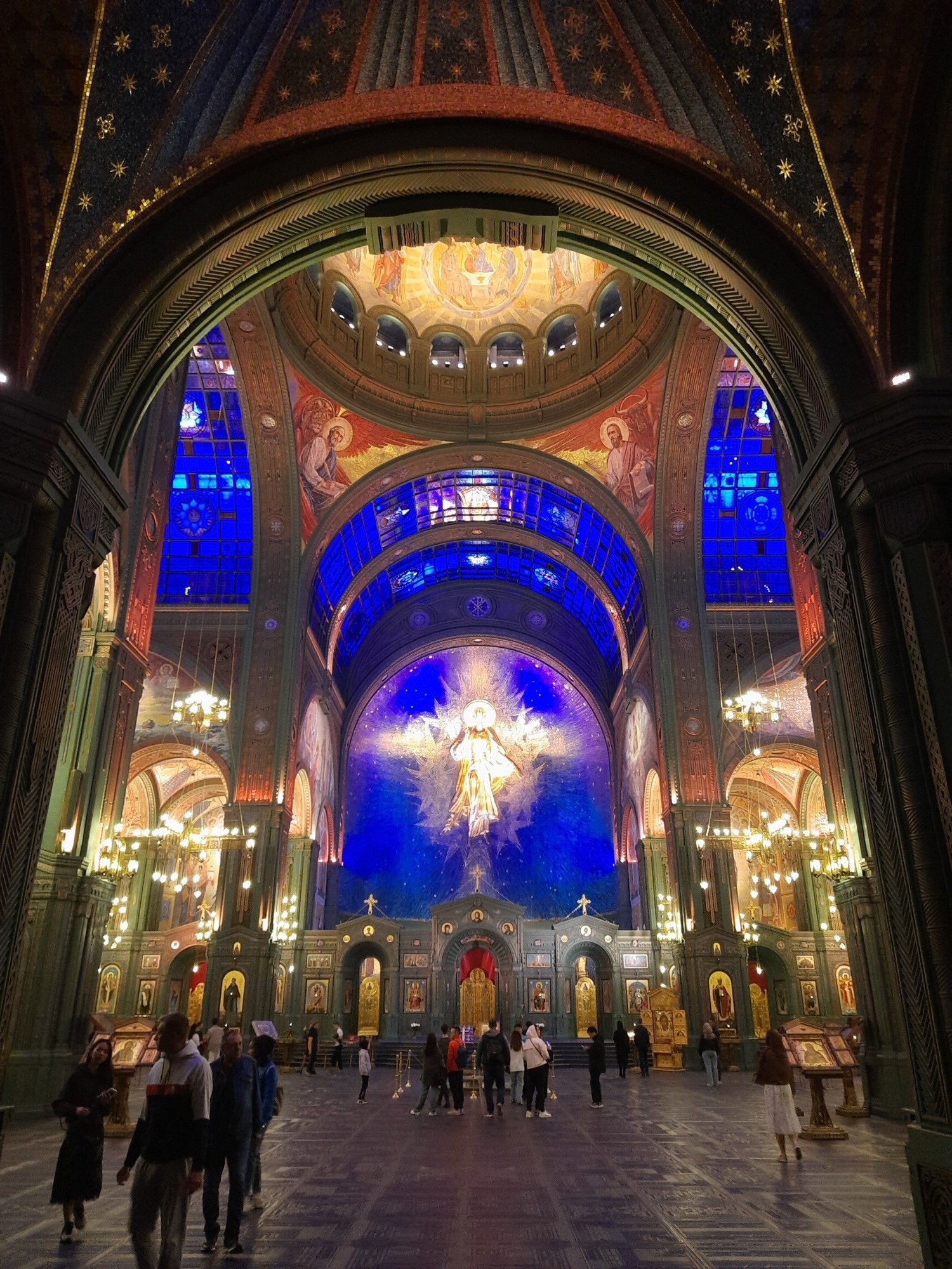 Interior of the Main Cathedral of the Russian Armed Forces showing the massive central dome with the mosaic of Christ, one of the largest images of Christ's face ever created in mosaic, surrounded by blue and gold iconography fusing Orthodox tradition with military imagery