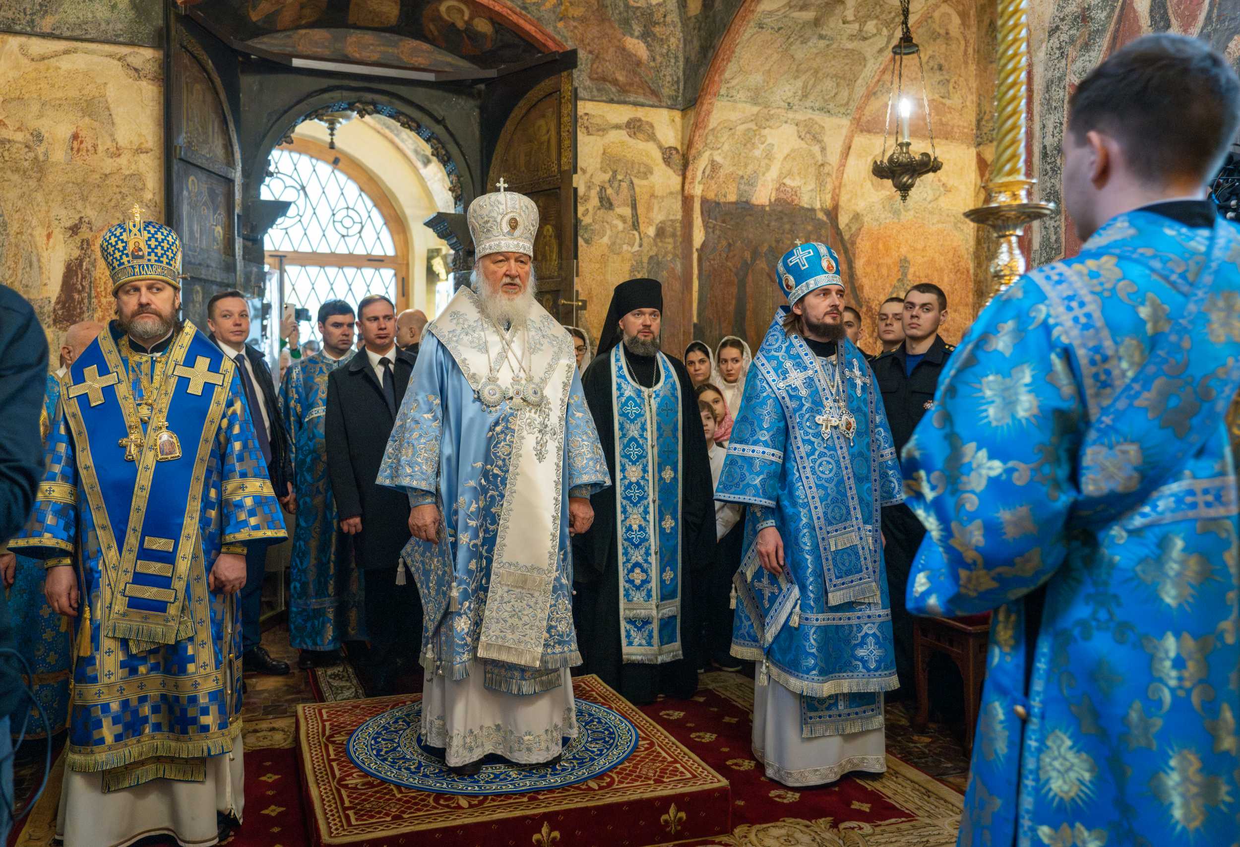 Patriarch Kirill in full liturgical vestments standing in the Annunciation Cathedral of the Moscow Kremlin, surrounded by concelebrating clergy