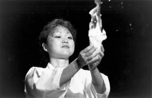 Chung Hyun Kyung burns a rice-paper scroll bearing the names of invoked spirits at the plenary session of the WCC Seventh Assembly, Canberra, 1991.