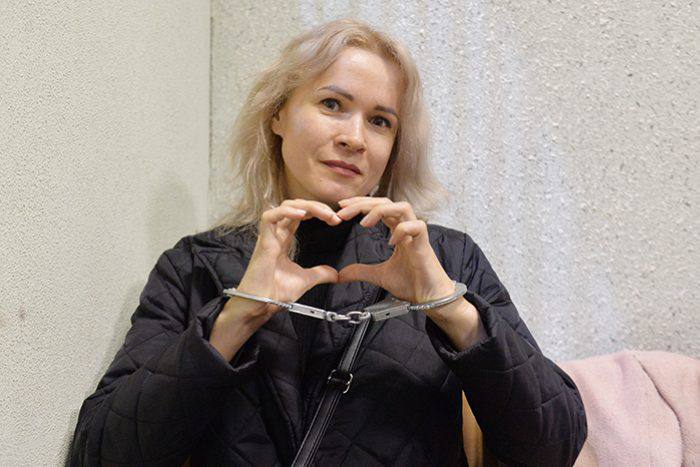 Maria Ponomarenko in handcuffs, making a heart sign with her hands, after being sentenced to six years in a Russian penal colony for reporting on the Mariupol theater bombing
