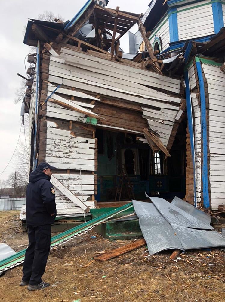 Close-up of the destroyed wooden church in Viazivka, showing the gaping hole in the structure